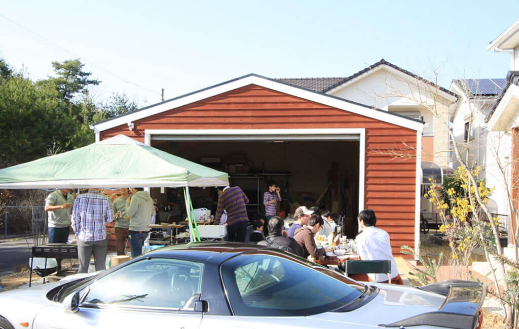 おしゃれなガレージの前でBBQパーティーする写真